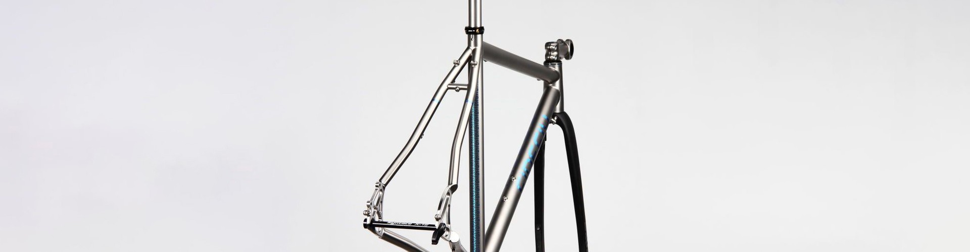 Close up view of bare titanium bicycle tubing joints and intricate welds