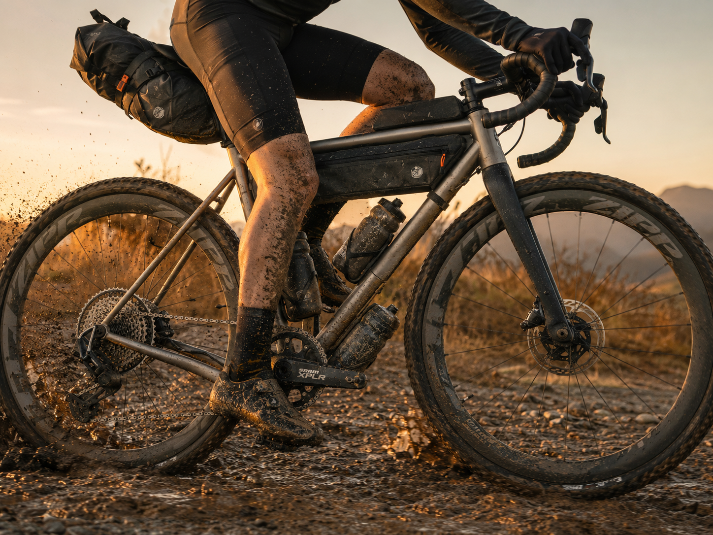 Rugged titanium gravel bike frame detailed shot against a dark textured background