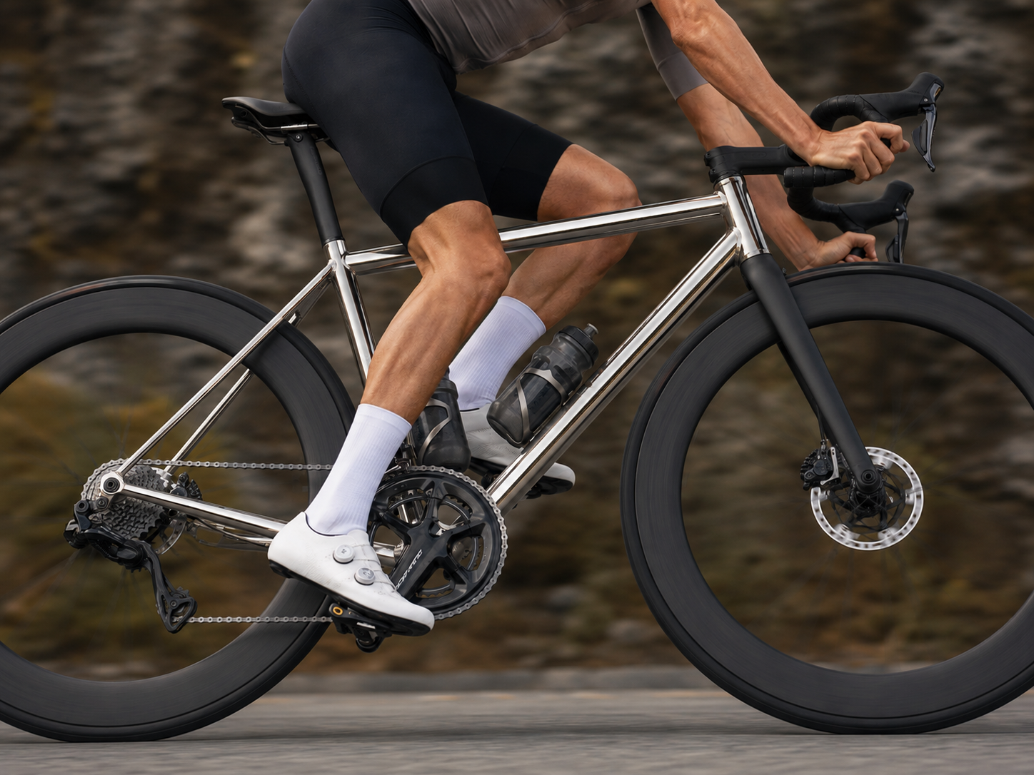 Minimalist side profile of a high-performance titanium road bicycle frame in a dark studio setting
